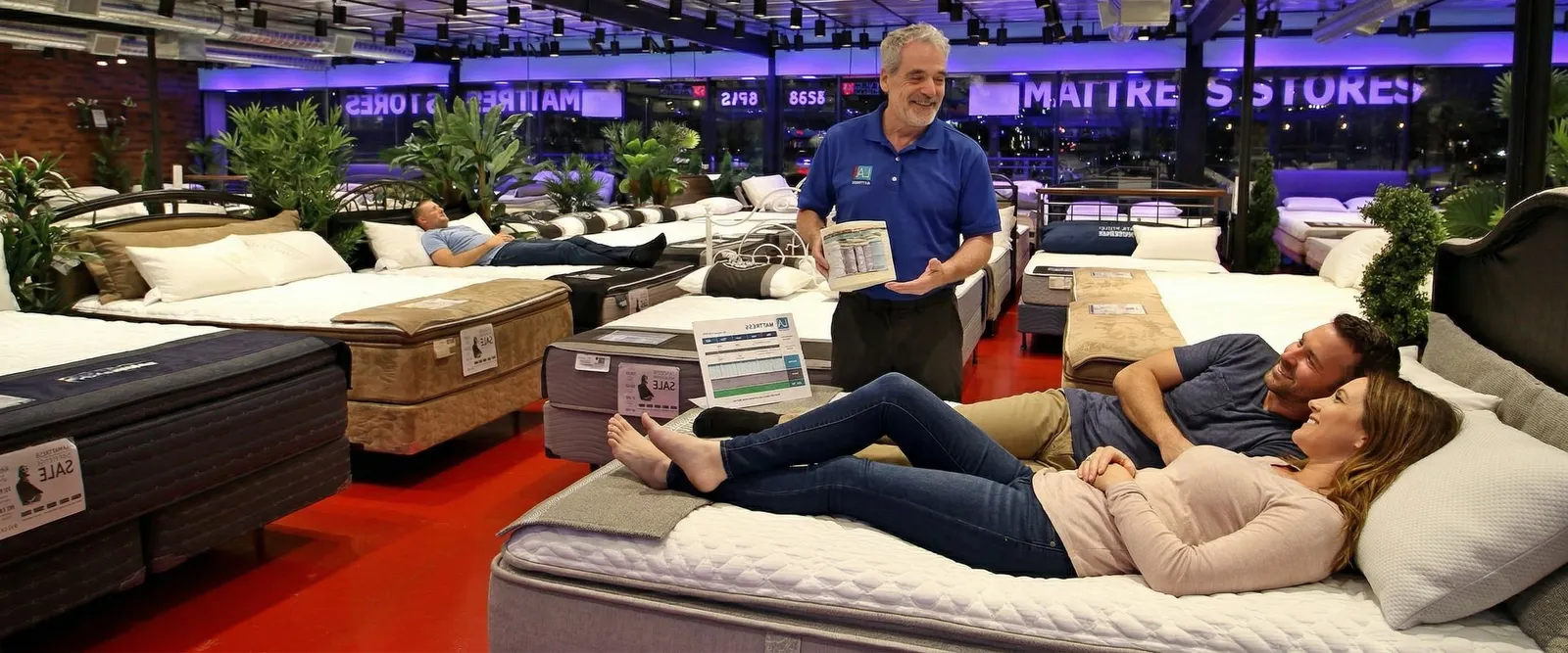 A couple trying a bed with an LA Mattress sleep specialist